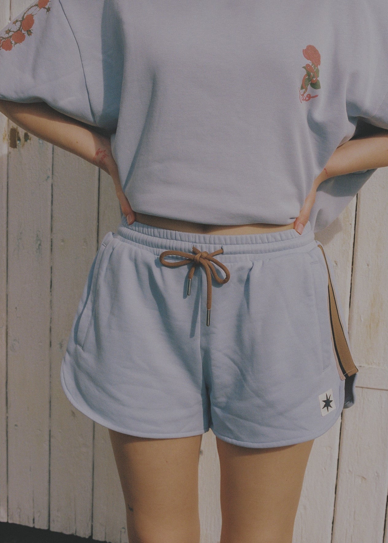Person wearing a light blue lounge set  with floral designs and brown detailing