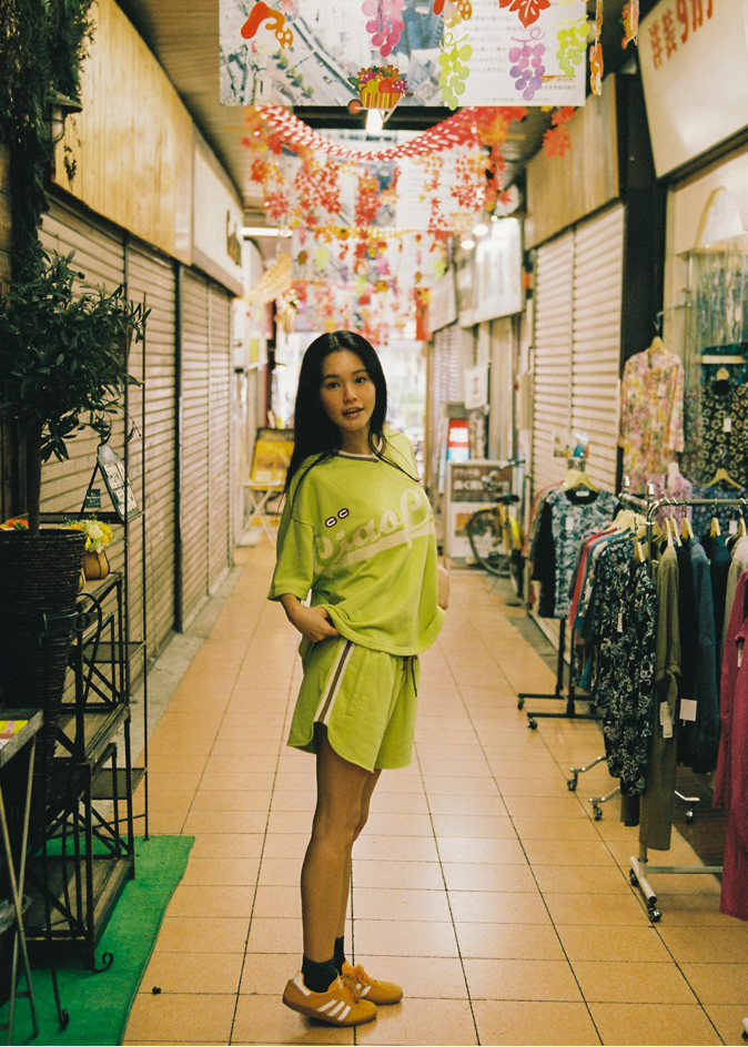 Woman in a bright green lounge jersey and drawstring shorts with CCV branding and logos
