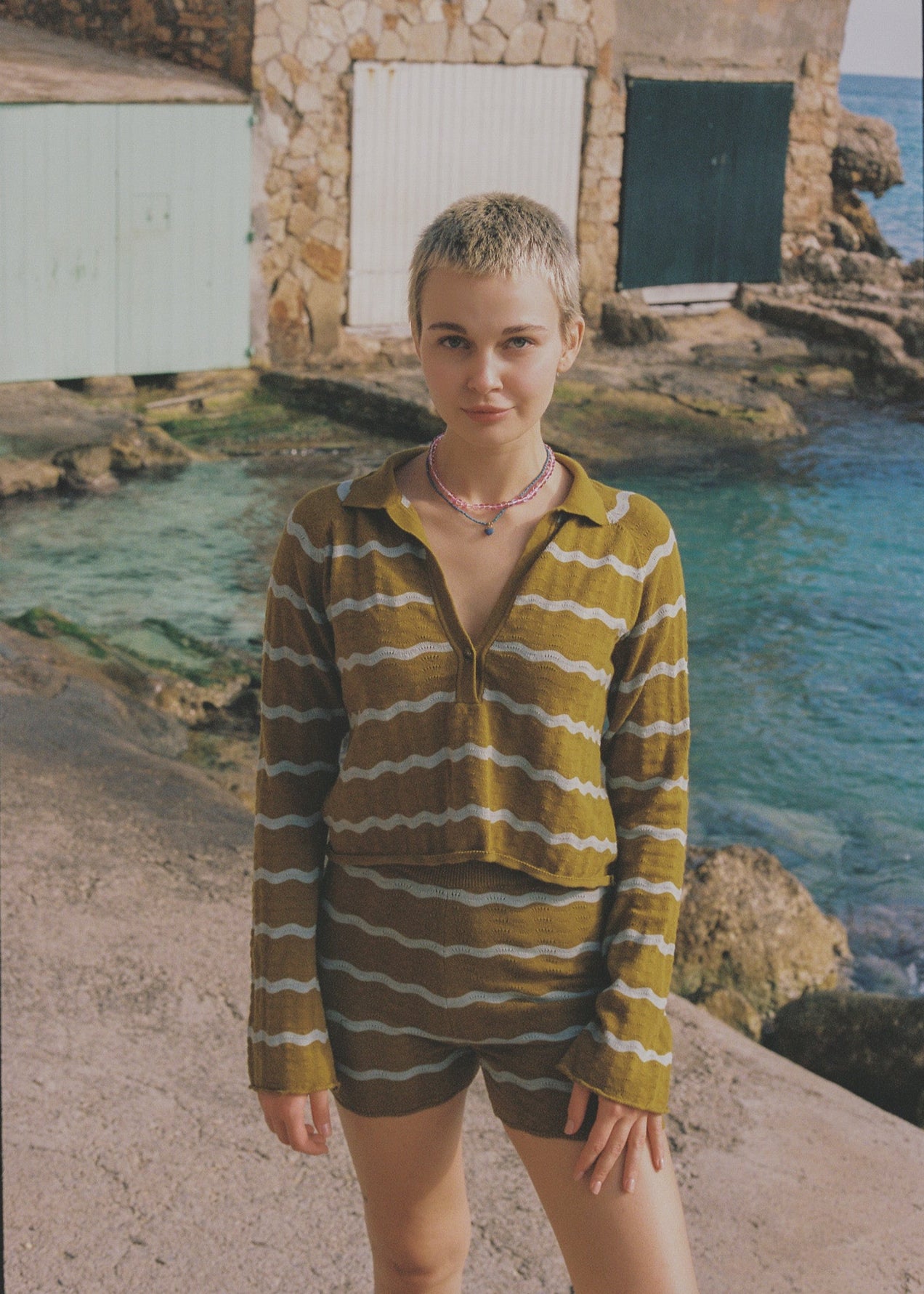 Person wearing a mustard and light blue striped shirt and shorts set