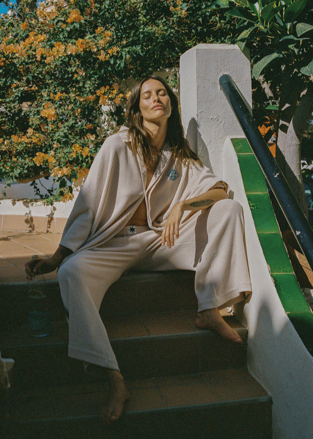 Women wearing loose fitting beige top and pants waffle set.