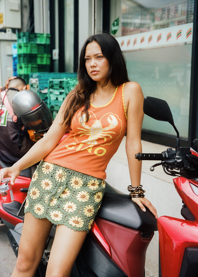 Woman wearing a green crochet skirt with yellow sunflower patterns in Thailand