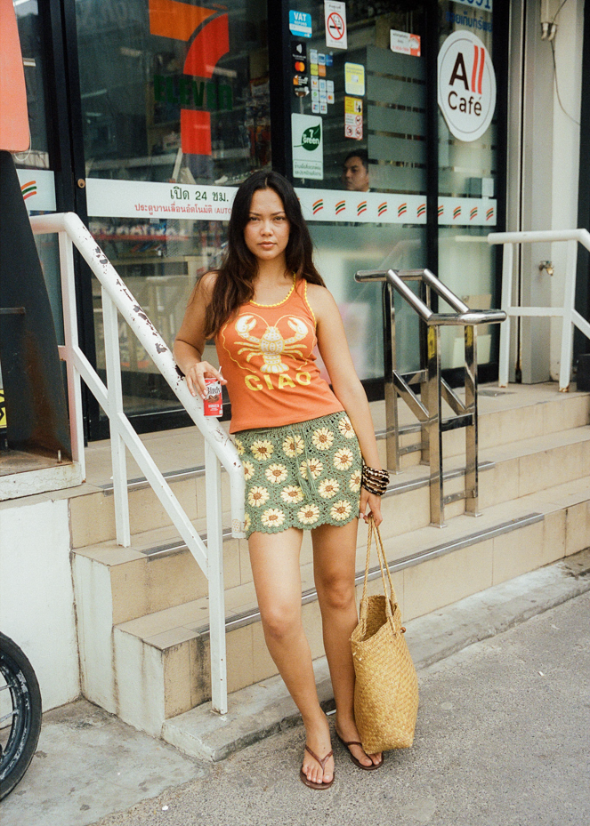 Woman wearing a green crochet skirt with yellow sunflower patterns in Thailand