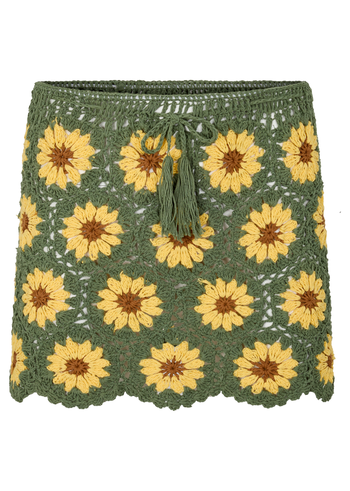 Green crochet skirt with yellow sunflower patterns on a white background