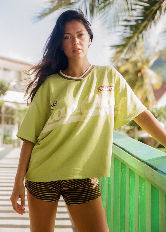 Woman wearing a bright green oversized jersey t-shirt with 'Ciao Ciao' text in Thailand