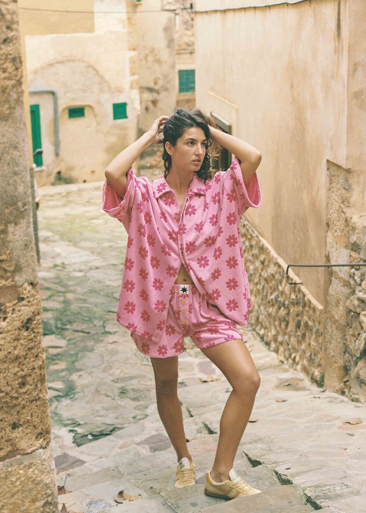 Wearing a pink daisy print matching oversized button up top and boxer bottoms.