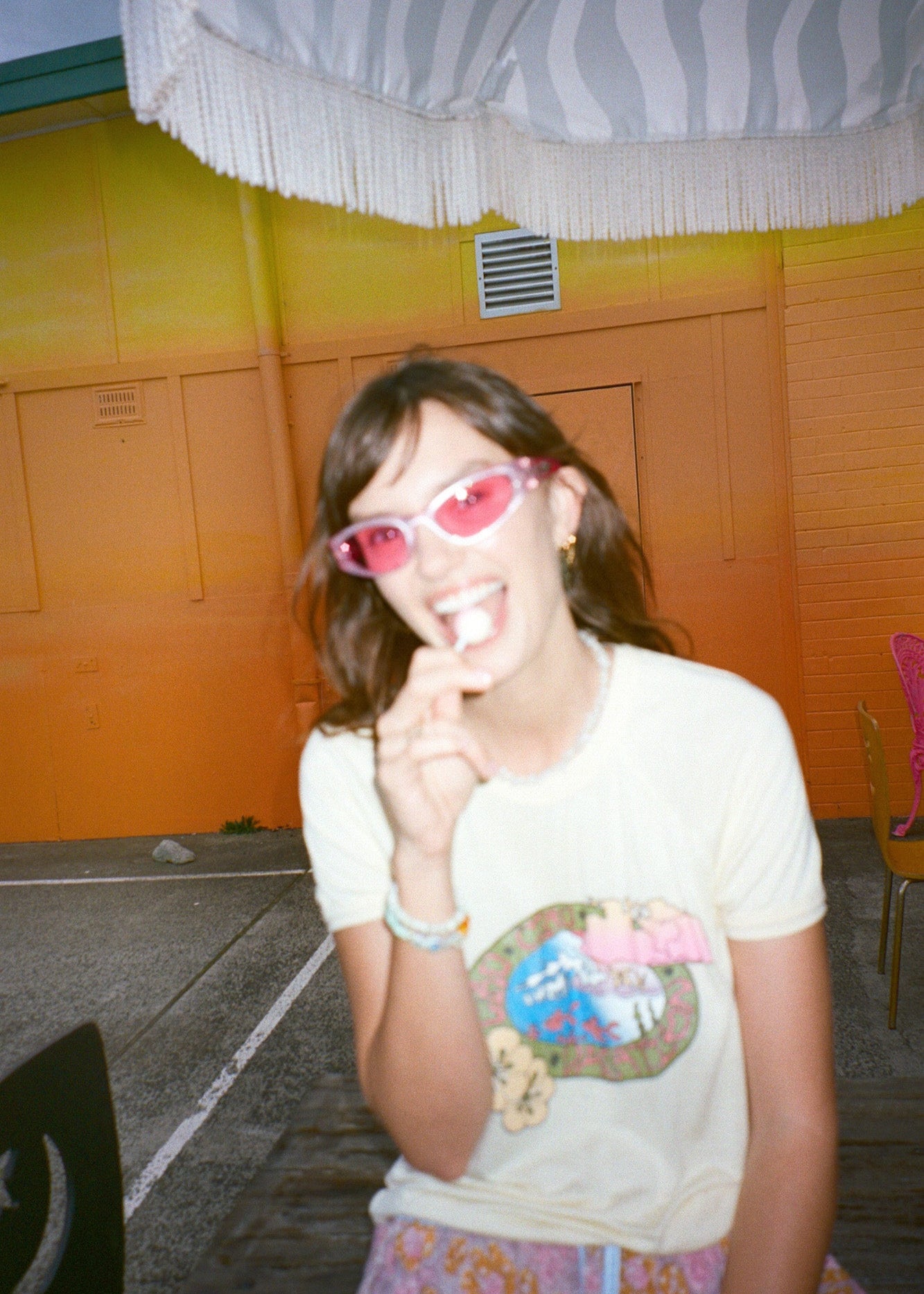 Person wearing yellow ringer tee with retro surf inspired graphic