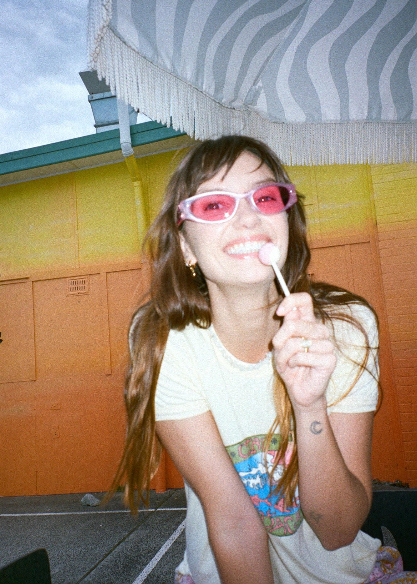 Person wearing yellow ringer tee with retro surf inspired graphic