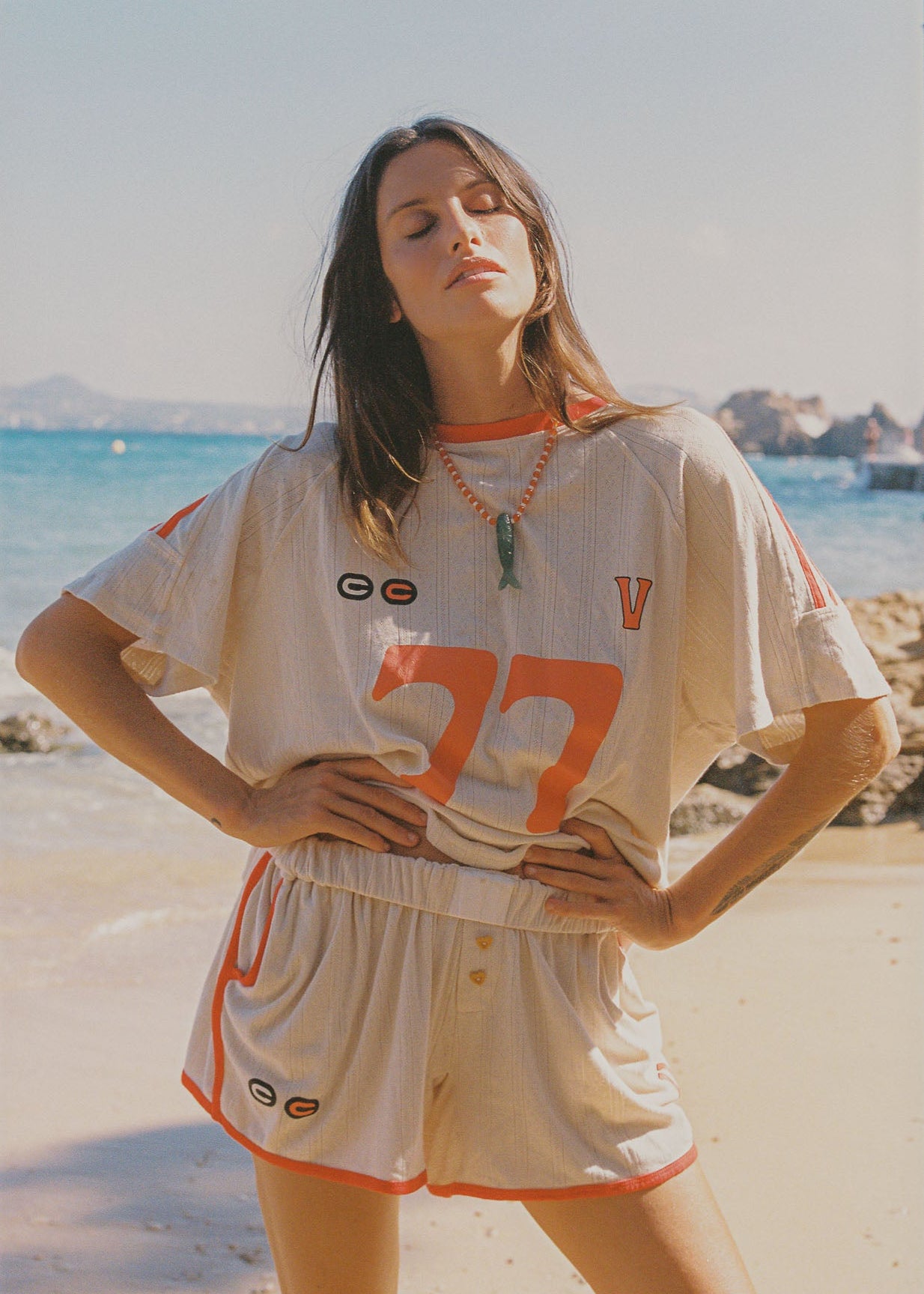 Wearing an oversized beige and orange racer t-shirt with matching beige and orange flowy fitting shorts. 