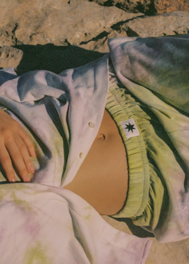 Close up of oversized tie-dye button up shirt with matching pants.